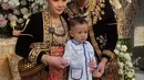 Penampilan Raffi Ahmad semakin memukau bak raja Jawa dengan topi khas berwarna biru, hiasan telinga yang serasi dengan kalungnya. [Foto: Instagram/raffinagita1717]