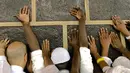 Umat muslim memagang bangunan Kakbah di Masjidil Haram, Mekah, Arab Saudi, Jumat (17/8). Dalam ritual ibadah haji umat muslim diharuskan tawaf atau berputar mengelilingi Kakbah berlawanan arah jarum jam. (AP Photo/ Dar Yasin)