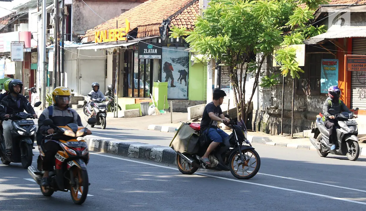 Pengendara sepeda motor hendak putar balik dan melawan arus di kawasan Jagakarsa, Jakarta, Minggu (6/1). Jauhnya akses putar balik menyebabkan para pemotor nekat melawan arah, meskipun membahayakan keselamatan. (Liputan6.com/Immanuel Antonius)