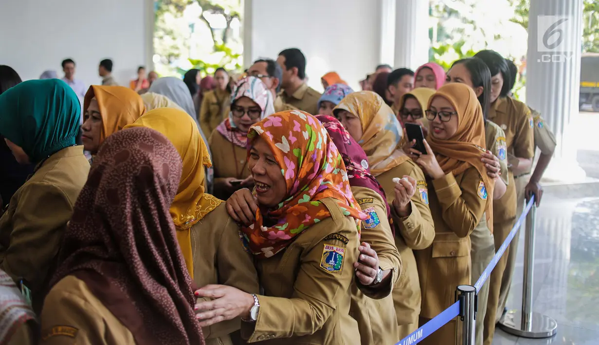 Pegawai Pemprov mengantre untuk bersalaman dengan Gubernur DKI Jakarta Anies Baswedan selama halal bihalal di Balaikota, Jakarta, Senin (10/6/2019). Pemerintah Provinsi DKI Jakarta menggelar Halal Bihalal pada hari pertama PNS masuk kerja setelah libur Lebaran 2019. (Liputan6.com/Faizal Fanani)