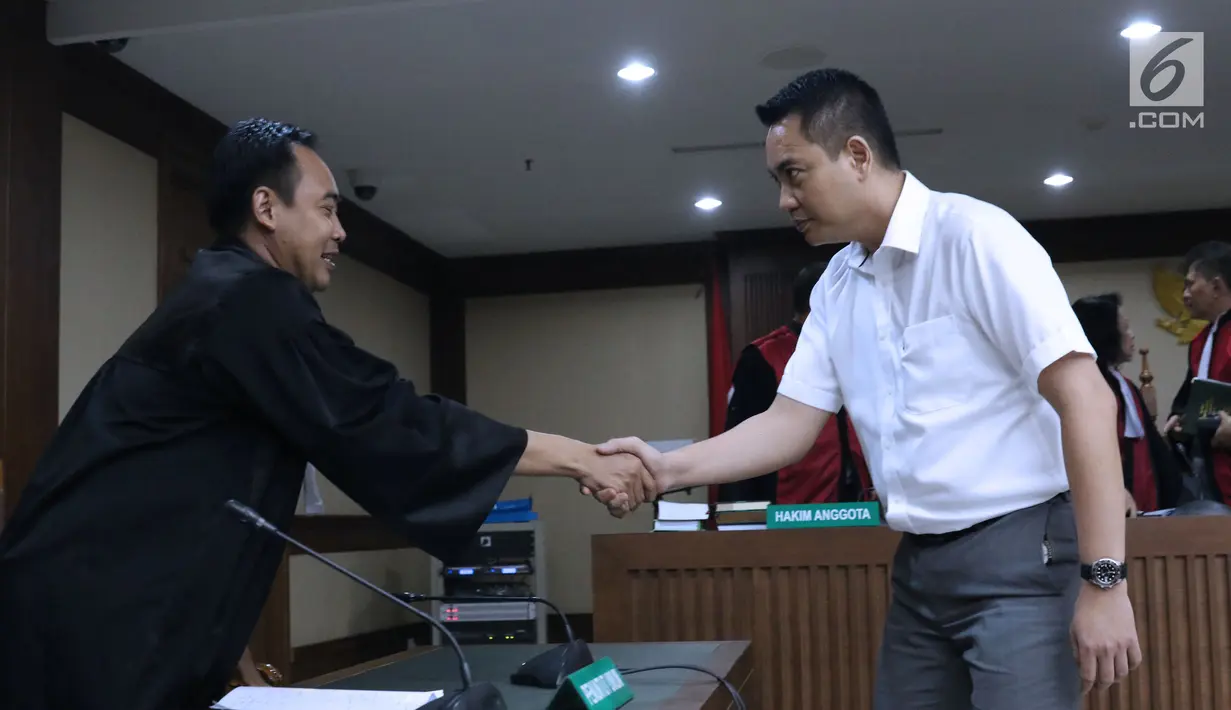 Terdakwa dugaan suap pengadaan satelit monitoring Bakamla, Fayakhun Andriadi (kanan) menyalami JPU KPK usai menjalani sidang tuntutan di Pengadilan Tipikor, Jakarta, Rabu (21/11). Fayakhun dihukum delapan tahun penjara. (Liputan6.com/Helmi Fithriansyah)