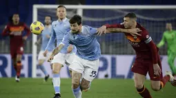 Bek Lazio, Francesco Acerbi (kiri) berebut bola dengan striker AS Roma, Edin Dzeko dalam laga lanjutan Liga Italia Serie A 2020/21 pekan ke-18 di Olympic Stadium, Roma, Jumat (15/1/2021). Lazio menang 3-0 atas AS Roma. (AFP/Filippo Monteforte)