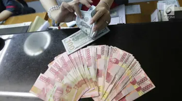 Teller menukarkan mata uang dolar ke rupiah di Jakarta, Jumat (2/2). Deputi Gubernur Senior BI Mirza Adityaswara mengatakan, posisi nilai tukar rupiah terhadap dolar Amerika Serikat yang berada di level Rp13.700 hingga Rp13.800.(Liputan6.com/Angga Yuniar)