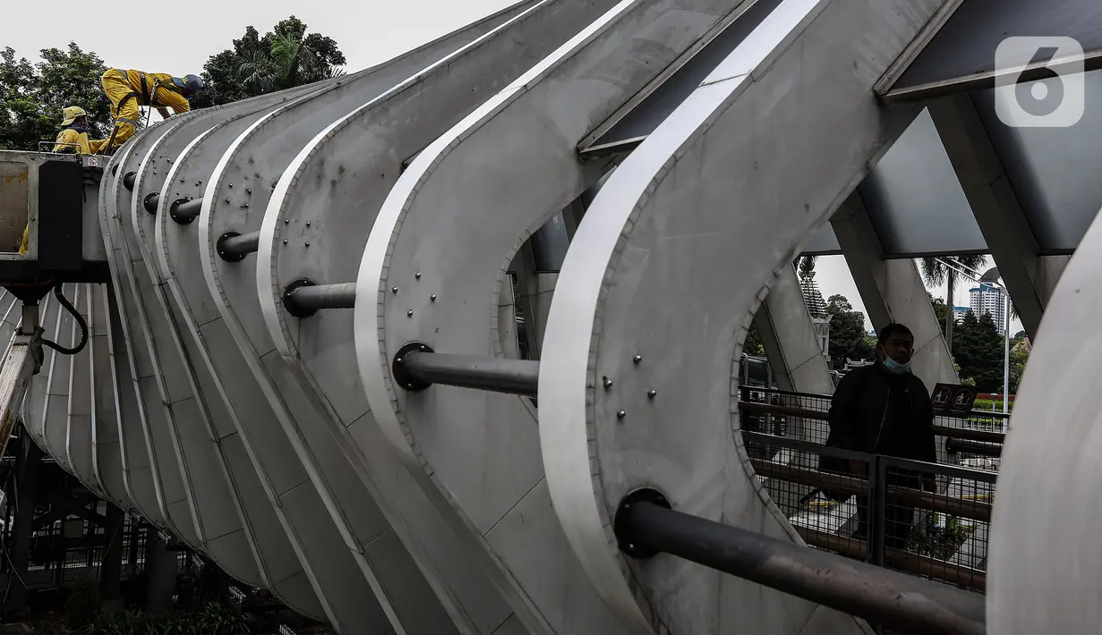 Aktivitas perawatan Jembatan Penyeberangan Orang (JPO) oleh pasukan kuning dari Dinas Bina Marga DKI Jakarta di Kawasan Sudirman, Senin (29/3/2021). Kegiatan tersebut dilakukan agar bersih terhidar dari debu serta para pemakai jembatan itu merasa aman dan nyaman. (Liputan6.com/Johan Tallo)