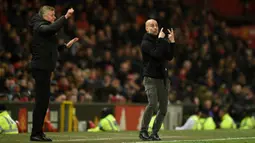 Pelatih Manchester City Pep Guardiola (kanan) dan Manajer Manchester United Ole Gunnar Solskjaer memberi isyarat kepada para pemain mereka saat pertandingan Liga Inggris di Old Trafford, Manchester, Inggris, Minggu (8/3/2020). Manchester United menang 2-0. (Oli SCARFF/AFP)