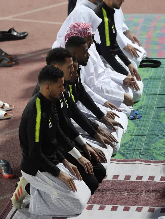 Para pemain Timas Qatar salat berjamaah sebelum sesi latihan mereka di Abu Dhabi (31/1). Qatar harus melewati Korea Selatan sebelum menginjakkan kakinya di final Piala Asia 2019. (AFP Photo/Roslan Rahman)