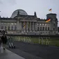 Orang-orang berjalan di depan Gedung Reichstag dan Bundestag di Berlin, Jerman, 17 November 2021. Badan pengendalian penyakit Jerman melaporkan 52.826 kasus baru COVID-19 pada 17 November 2021 karena tingkat infeksi terus meningkat. (AP Photo/Markus Schreiber)