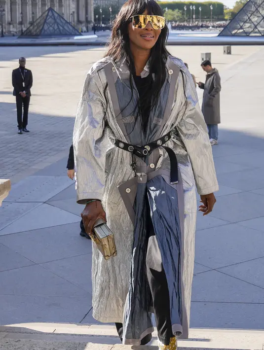 Naomi Campbell saat tiba menghadiri koleksi busana Louis Vuitton Spring/Summer 2023 yang dipresentasikan selama Paris Fashion Week di Paris pada Selasa, 4 Oktober 2022. Di bawah mantel parit perak, supermodel itu mengenakan kemeja hitam ketat dan celana panjang hitam kaki lebar dan palazzo, sempurna untuk menciptakan kontras kromatik yang tajam dan tegas yang langsung menarik perhatian ke dalam mata. (AP Photo/Francois Mori)