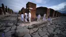 Wisatawan berjalan melewati Via del Vesuvio (kiri) yang berbatu, Pompeii, Italia, Senin (25/11/2019). Meski butuh 1.500 tahun untuk ditemukan, kondisi rumah, benda-benda, hingga jenazah warga Pompeii masih cukup utuh saat ditemukan. (Filippo MONTEFORTE/AFP)