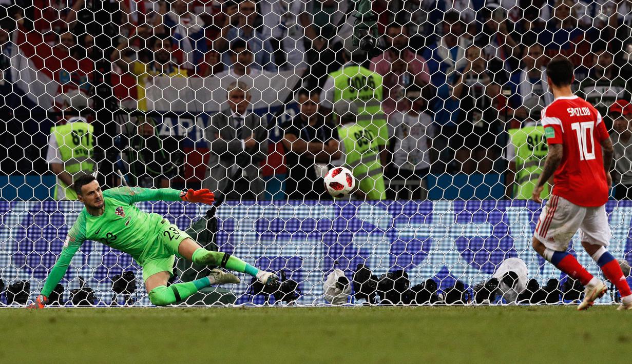 Fedor Smolov. Striker Rusia berusia 32 tahun yang kini bermain bersama Dynamo Moscow ini menjadi pemain kelima yang melakukan eksekusi penalti dengan gaya Panenka di Piala Dunia. Momen itu terjadi saat Rusia kalah melalui adu penalti 3-4 (1-1) dari Kroasia pada babak perempatfinal Piala Dunia 2018 (7/7/2018) di Rusia. Sebagai penendang pertama, eksekusi penalti Panenka-nya gagal karena mampu dibaca kiper Kroasia, Danijel Subasic. (AFP/Adrian Dennis)