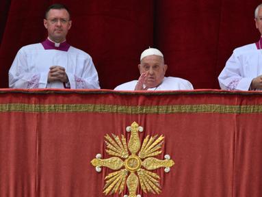 Paus Fransiskus (tengah) saat berada di balkon utama Basilika Santo Petrus sebelum menyampaikan pesan Urbi et Orbi atau kepada kota (Roma) dan dunia sebagai bagian dari perayaan Paskah, di alun-alun Santo Petrus di Vatikan pada tanggal 20 April 2025. (Andreas SOLARO/AFP)