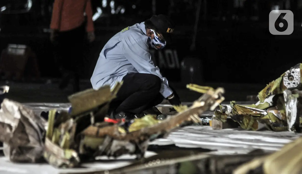 Tim KNKT mengidentifikasi serpihan pesawat Sriwijaya Air SJ 182 di Dermaga JICT 2, Tanjung Priok, Jakarta, Minggu (10/1/2021). Pencarian Sriwijaya Air SJ 182 tetap dilakukan pada malam hari meski secara terbatas. (merdeka.com/Iqbal S. Nugroho)