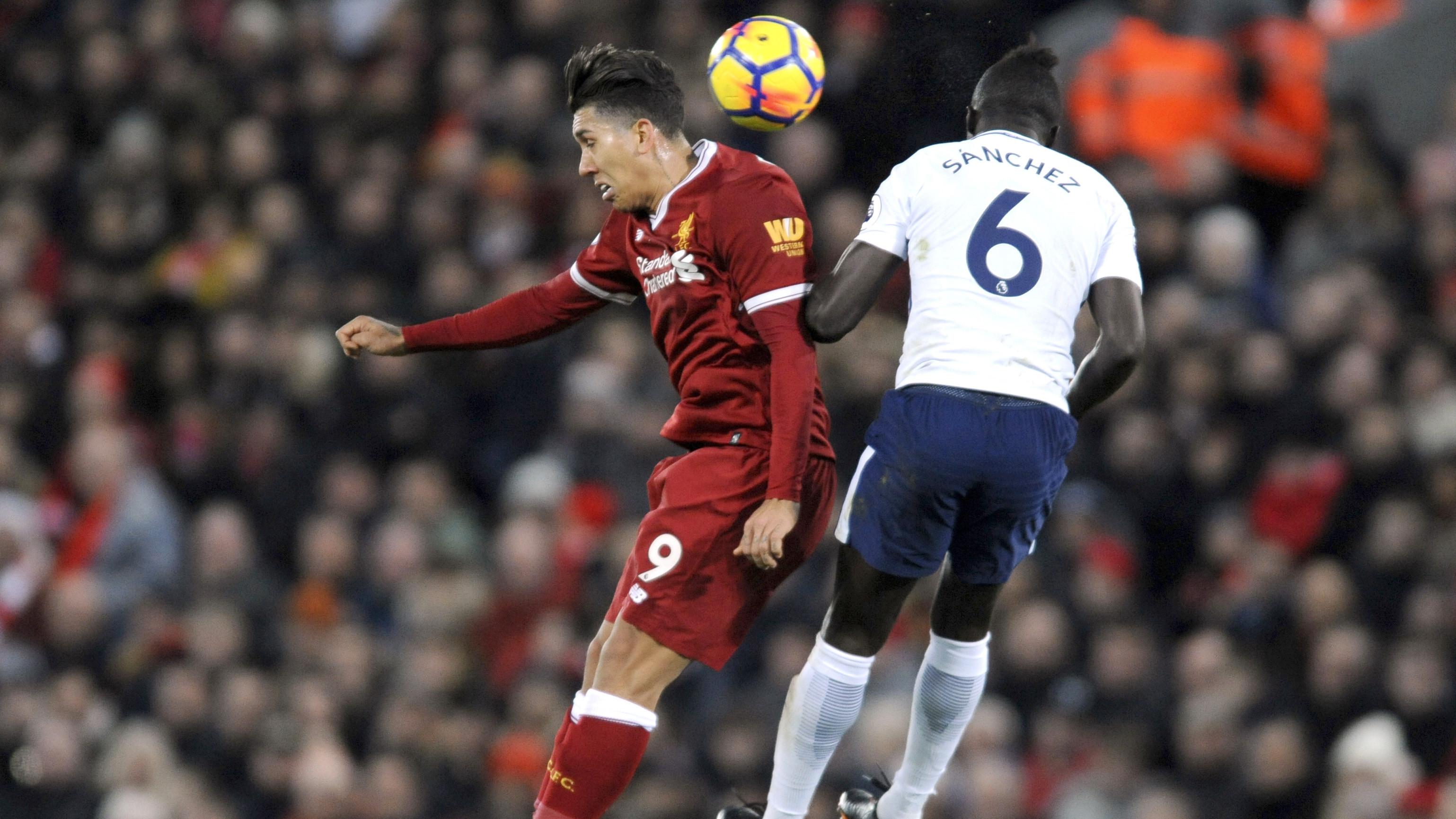 Duel pemain Liverpool, Roberto Firmino (kiri) dan pemain Tottenham, Davinson Sanchez pada lanjutan premier League di Anfield, Liverpool, (4/2/2018). Liverpool bermain imbang 2-2 dengan Tottenham. (AP/Rui Vieira)