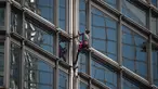 Alain Robert yang dijuluki 'French Spiderman' memanjat gedung pencakar langit Cheung Kong Center di Hong Kong, Jumat (16/8/2019). Pria berusia 57 tahun tersebut memanjat Cheung Kong Center dalam kondisi panas dan lembab pada Jumat pagi. (Lillian SUWANRUMPHA/AFP)