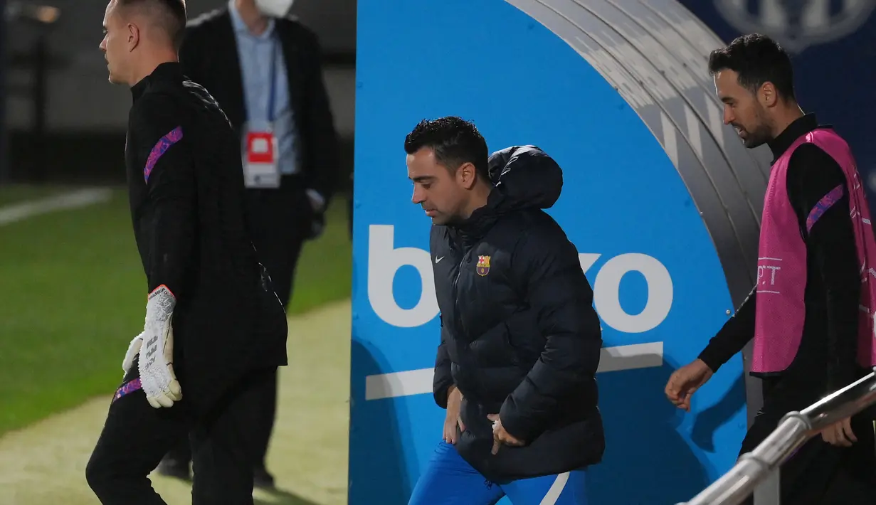 Pelatih Barcelona Xavi dan gelandang Spanyol Barcelona Sergio Busquets tiba untuk sesi latihan di stadion Camp Nou di Barcelona, Spanyol (22/11/2021). Barcelona akan bertanding melawan Benfica pada Grup E Liga Champions di Camp Nou. (AFP/Gen Lluis)