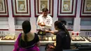 Gambar diambil pada 11 Agustus 2021 menunjukkan seorang manajer toko perhiasan berbicara dengan pelanggan di Mumbai, India. Putus asa mendapatkan uang tunai, banyak keluarga dan usaha kecil menjual perhiasan emas sebagai jaminan untuk mendapatkan pinjaman jangka pendek. (Punit PARANJPE/AFP)