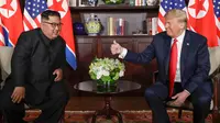 Presiden AS Donald Trump  memberikan jempolnya seusai berjabat tangan dengan Pemimpin Korea Utara, Kim Jong-un dalam pertemuan bersejarah di resor Capella, Pulau Sentosa, Selasa (12/6). Trump dan Kim saling melemparkan senyum. (AP/Evan Vucci)