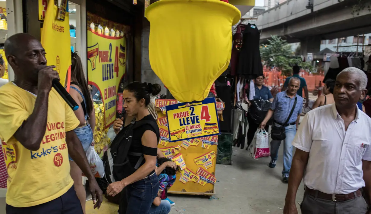 Pedagang menawarkan celana dalam berwarna kuning di Medellin, Kolombia, Jumat (29/12). Selain di Kolombia, tradisi mengenakan celana dalam kuning pada perayaan tahun baru sudah lama dianut warga beberapa negara di Amerika. (Joaquin SARMIENTO / AFP)
