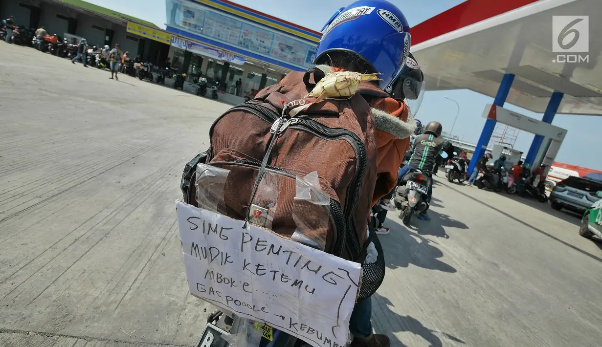 Pemudik sepeda motor menempelkan pesan di tasnya saat  mengisi bahan bakar di SPBU kawasan Brebes, Jawa Tengah, Minggu (2/6/2019). Sejumlah SPBU di Brebes terpantau ramai oleh para pemudik yang mengisi bahan bakar kendaraannya. (Liputan6.com/Herman Zakharia)