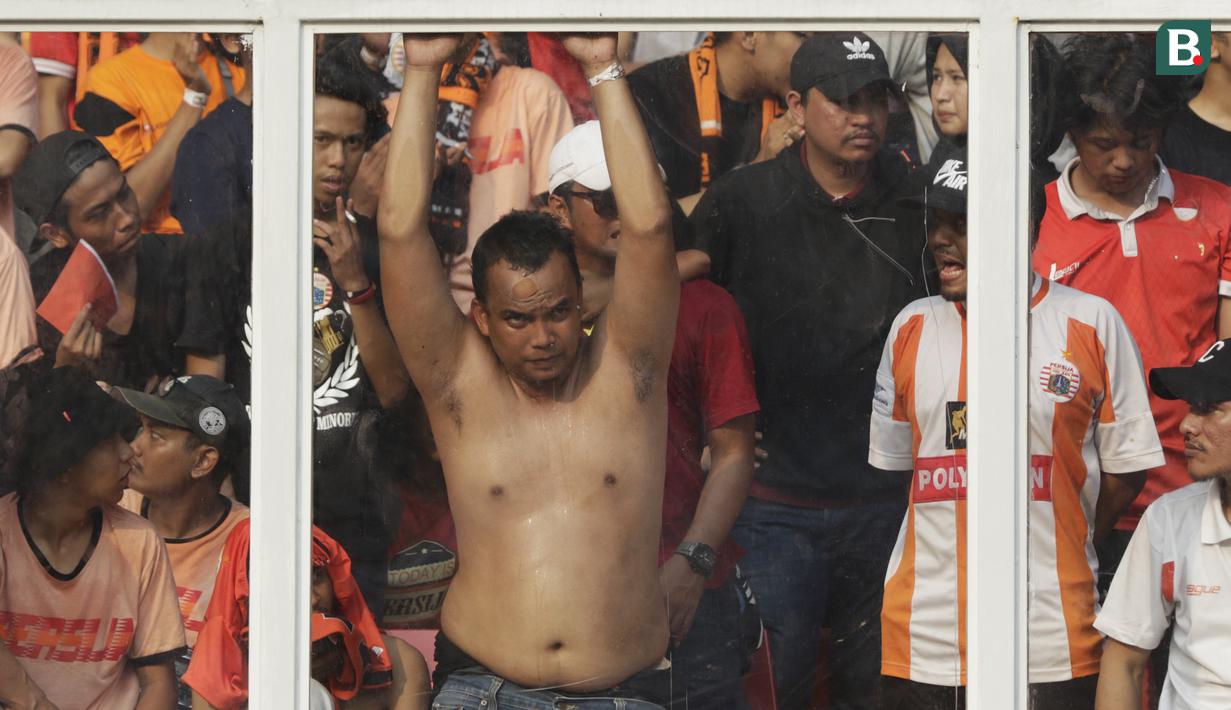 Suporter Persija, The Jakmania, membukan baju memberikan dukungan saat melawan Persela pada laga Liga 1 di SUGBK, Jakarta, Selasa (20/11). Persija menang 3-0 atas Persela. (Bola.com/Vitalis Yogi Trisna)