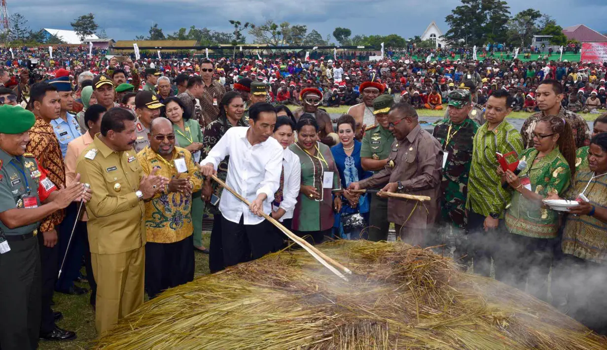 Presiden Joko Widodo dan Ibu Negara saat mengikuti ‎upacara Bakar Batu bersama masyarakat Pegunungan Tengah Papua di Stadion Mini Pendidikan, Distrik Wamena, Kabupaten Jayawijaya‎, Rabu (30/12). (Rumgapres)