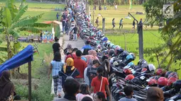 Warga memarkir sepeda motornya saat akan menyaksikan surutnya Danau Rawa Pening di Dusun Cikal , Tuntang, Semarang, Jawa Tengah, Minggu ( 30/9). Danau seluas 2.670 hektare itu berubah menjadi padang rumput luas. (Liputan6.com/Gholib)