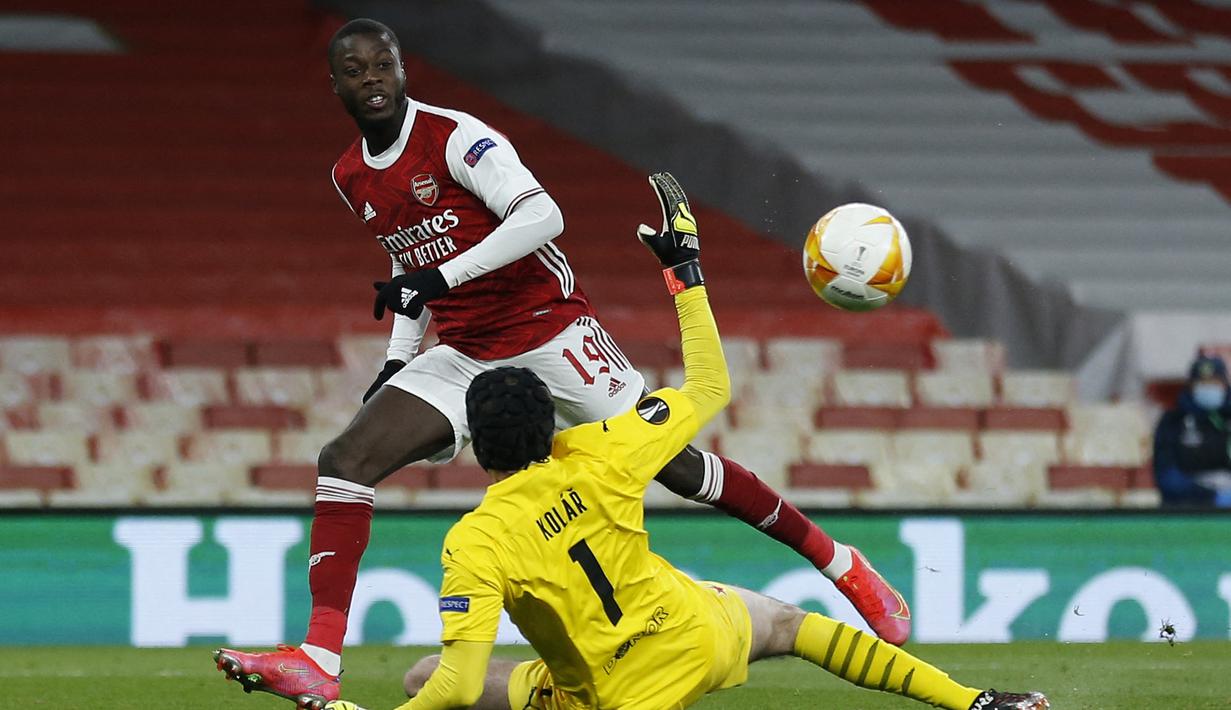 Gelandang Arsenal, Nicolas Pepe mencetak gol ke gawang Slavia Praha pada laga leg pertama babak perempatfinal Liga Europa 2020/2021 di Emirates Stadium, London (8/4/2021). Nicolas Pepe hingga kini tercatat sebagai pemain Afrika termahal yang pernah didatangkan klub di Liga Inggris. Pemain asal Pantai Gading ini didatangkan Arsenal dari LOSC Lille pada awal musim 2019/2020 dengan nilai transfer mencapai 80 juta euro atau kini setara Rp1,3 triliun. Saat ini ia tengah dipinjamkan The Gunners ke OGC Nice hingga akhir musim 2022/2023. (AFP/Ian Kington)