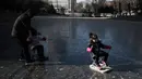 Sejumlah anak bermain di sungai yang membeku di Beijing, China (21/1). Akibat membeku, Sungai ini menjadi objek wisata dadakan yang banyak diminati wisatawan. (AFP/Fred Dufour)