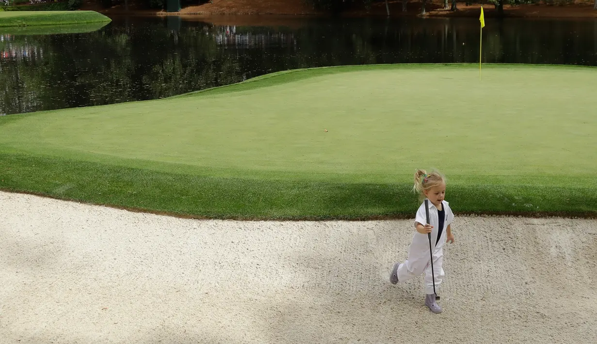 Putri dari pegolf Amerika Serikat Billy Horschel, Skylar Horschel berlarian saat mengikuti sang ayah pada hari terakhir latihan untuk turnamen golf Masters 2018 di Augusta, Georgia, Rabu (4/4). (AP Photo/Matt Slocum)