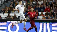 Penyerang Serbia, Aleksandar Mitrovic mengontrol bola dari kejaran bek Portugal Ricardo Carvalho pada kualifikasi Piala Eropa 2016 di stadion Luz, Lisbon, Minggu (29/3/2015). Portugal menang 2-1 atas Georgia. (REUTERS/Rafael Marchante)