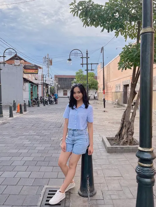 Seperti potret ini, Lyodra memadukan short shirt warna biru muda dengan short jeans warna senada dan sneakers putih. (Instagram/lyodraofficial).
