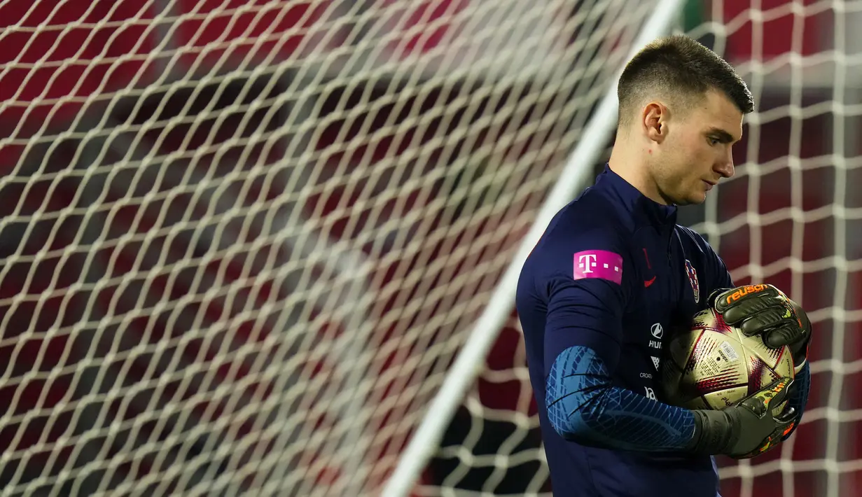 Kiper Kroasia Dominik Livakovic memegang bola saat sesi latihan timnas Kroasia pada Piala Dunia 2022 di Doha, Minggu (11/12/2022). Timnas Kroasia akan berduel melawan Argentina memperebutkan tiket final Piala Dunia 2022 di Stadion Lusail Iconic Qatar, Rabu (14/12/2022) mulai pukul 02.00 WIB. (AP Photo/Petr David Josek)