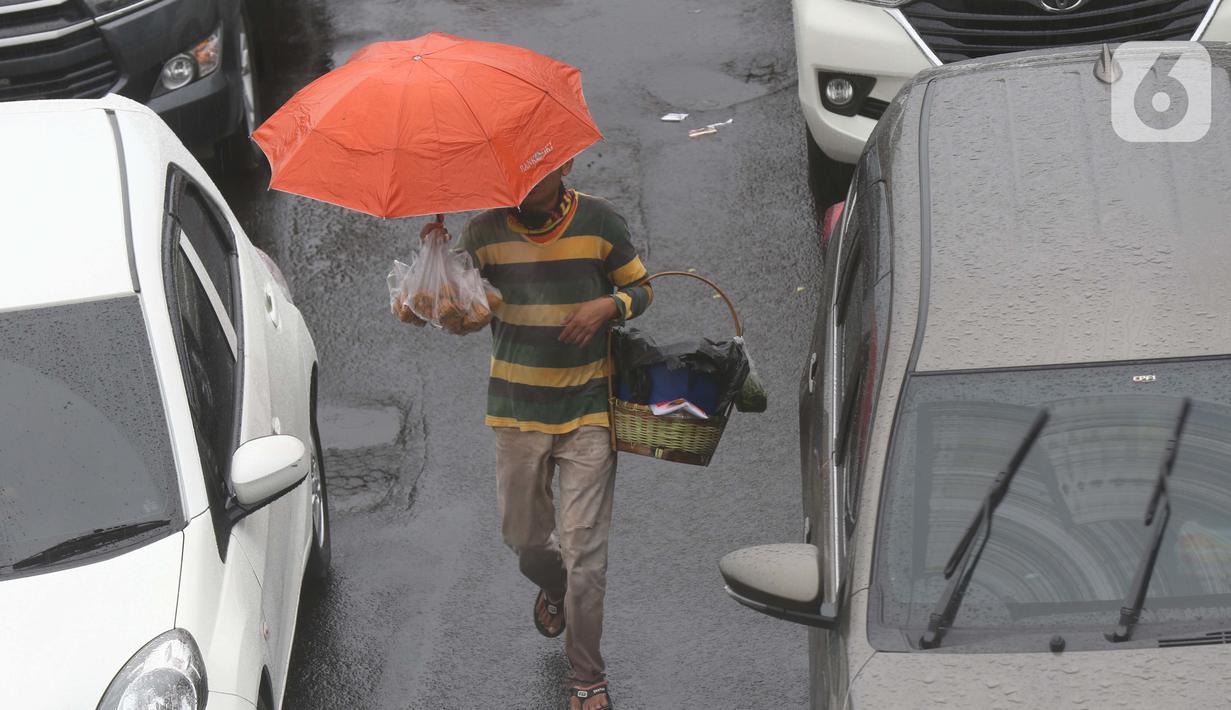 Seorang pedagang asongan menawarkan dagangan kepada pengendara di jalan tol Jagorawi yang sedang menanti waktu buka tutup jalur menuju kawasan wisata puncak, Bogor, Jawa Barat, Sabtu (31/10/2020). (Liputan6.com/Helmi Fithriansyah)