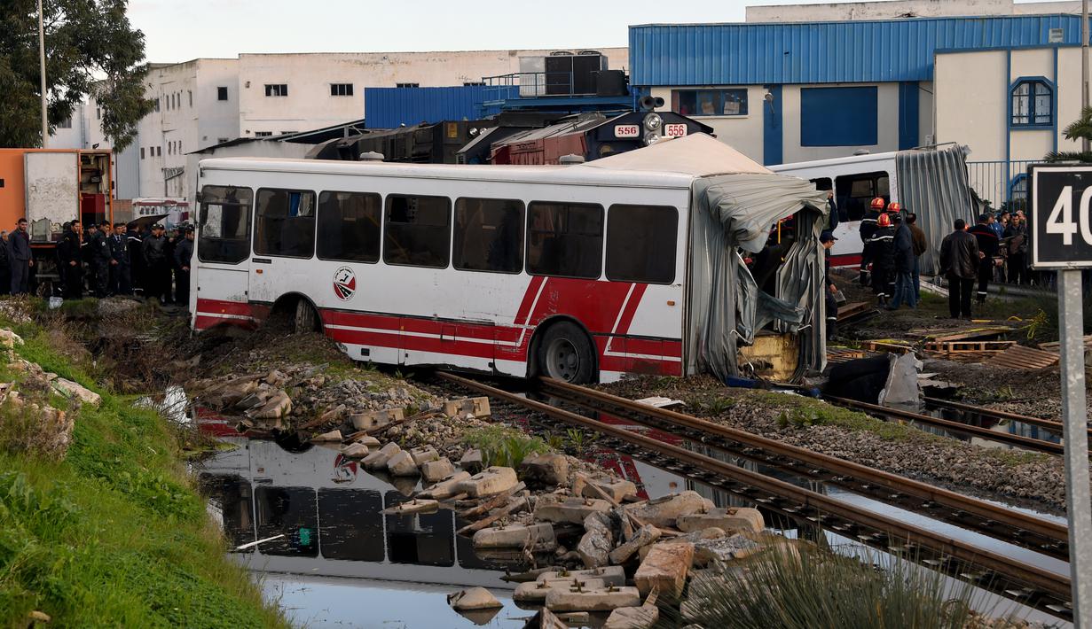 Sebuah kereta menghantam bus yang melintas di rel dekat wilayah Sidi Fathallah, sekitar 10 km selatan Ibu Kota Tunisia, Rabu (28/12). Bus itu terbelah dua ketika dihantam kereta dan menyebabkan lima orang tewas serta 34 lainnya terluka. (Fethi Belaid/AFP)