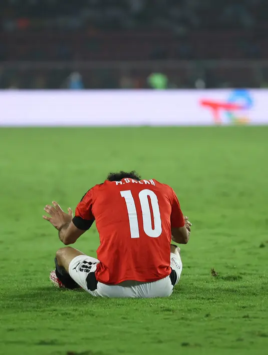 Reaksi penyerang Mesir Mohamed Salah pada laga final Piala Afrika 2021 menghadapi Senegal di Paul Biya Stadium, Senin (07/02/2022) dini hari WIB. Senegal berhasil menjuarai Piala Afrika 2021 setelah menang 4-2 atas Mesir via adu penalti. (Daniel BELOUMOU OLOMO / AFP)