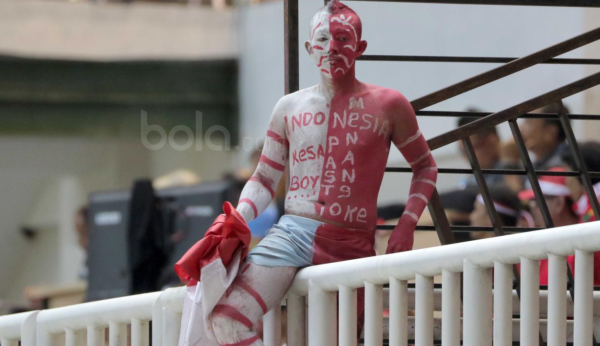 Seorang suporter Timnas Indonesia dengan tubuh berwarna Merah-Putih hadir mendukung  Indonesia melawan Vietnam pada laga Semifinal AFF Cup 2016 di Stadion Pakansari, Bogor, (03/12/2016). (Bola.com/Nicklas Hanoatubun)