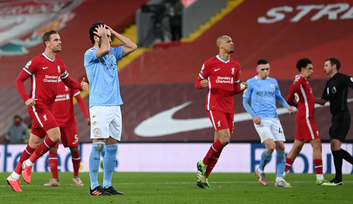 Gelandang Manchester City, Ilkay Gundogan (kedua dari kiri) kecewa usai gagal mencetak gol dari eksekusi penalti ke gawang Liverpool dalam laga lanjutan Liga Inggris 2020/21 pekan ke-23 di Anfield Stadium, Minggu (7/2/2021). Manchester City menang 4-1 atas Liverpool. (AFP/Jon Super/Pool)