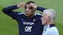 Pemain Prancis, Kylian Mbappe (kiri) di samping pelatih Didier Deschamps saat berlatih jelang laga Grup D melawan Belanda di Home Deluxe Arena Stadium, Paderborn, Jerman, Rabu (19/06/2024) waktu setempat. Mbappe terlihat menggunakan perban hidung setelah mengalami cedera patah tulang hidung pada laga Grup D Prancis melawan Austria Selasa (18/06/2024) WIB lalu. (AP Photo/Hassan Ammar)