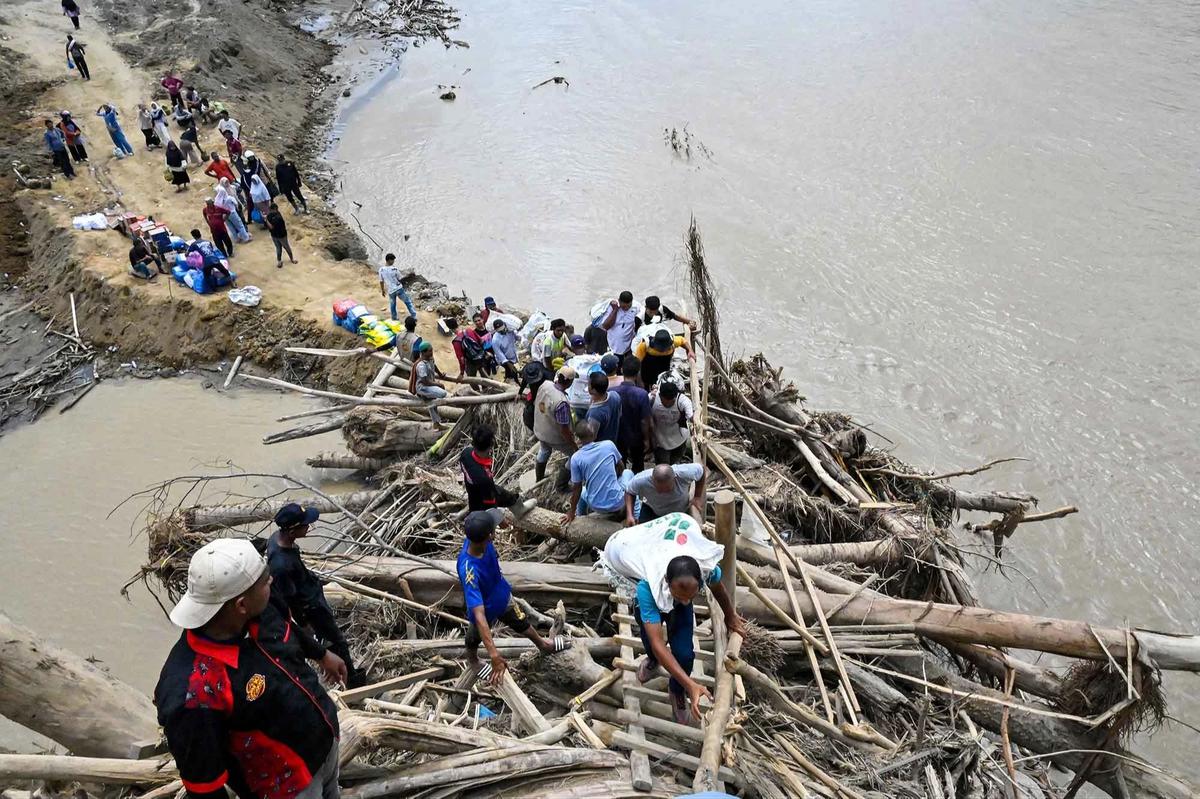 FOTO: Warga Memanjat Puing Kayu Demi Menyeberangi Sungai Peusangan