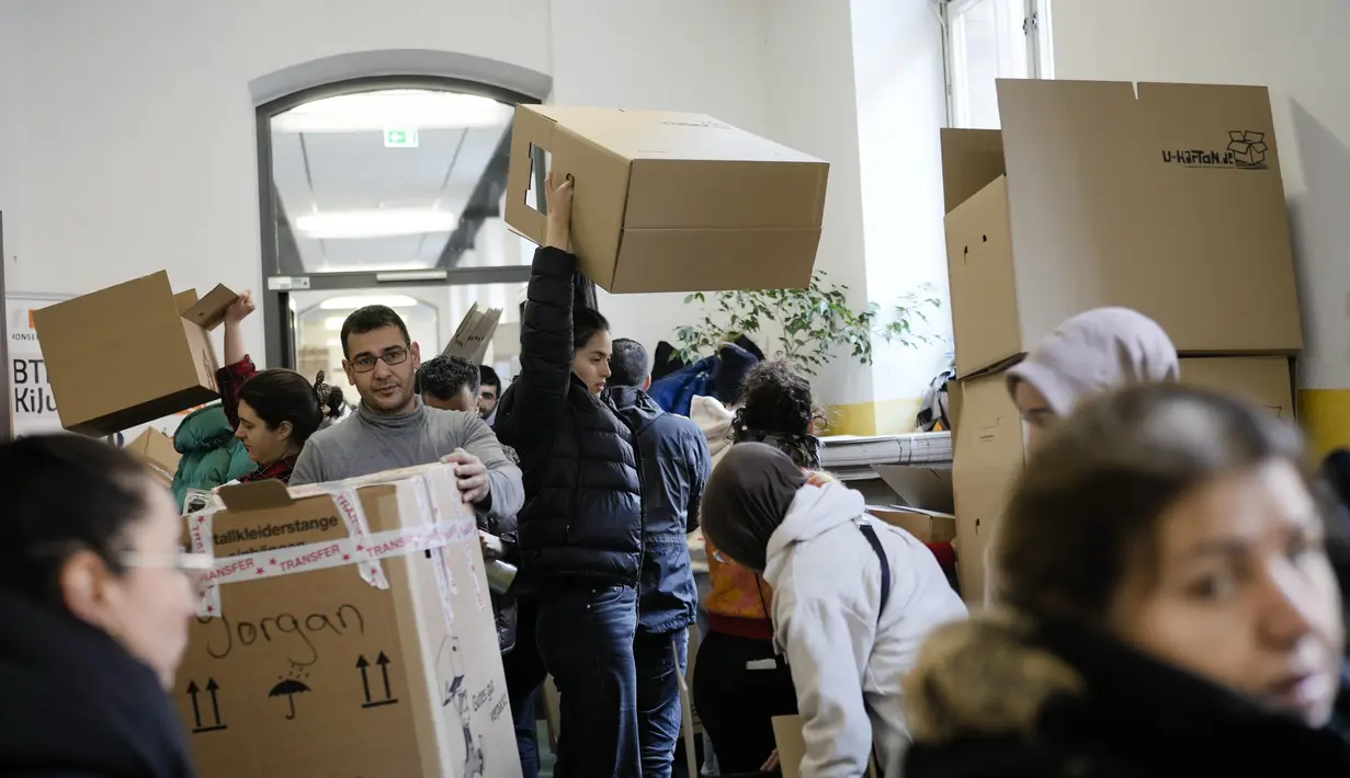 Orang-orang menumpuk kotak berisi persediaan bantuan di lorong yang ramai di tempat pengumpulan komunitas Turki di Berlin, Jerman, Selasa, 7 Februari 2023. Ratusan anggota komunitas Turki Berlin berbondong-bondong ke sekolah musik di ibu kota Jerman untuk menyumbangkan barang-barang penting. pasokan kemanusiaan setelah gempa dahsyat yang melanda Turki dan Suriah pada Senin. (AP Photo/Markus Schreiber)