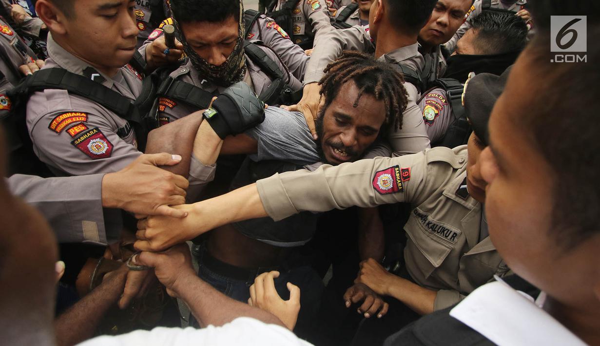 Massa yang tergabung dalam Front Rakyat Indonesia untuk West Papua (FRI-WP) dan Aliansi Mahasiswa Papua (AMP) terlibat aksi saling dorong dengan polisi saat unjuk rasa di Jalan Medan Merdeka Barat, Jakarta, Selasa (15/8). (Liputan6.com/Immanuel Antonius)