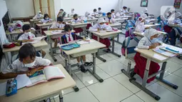 Siswa mengikuti Pembelajaran Tatap Muka (PTM) di SDN 01 Pondok Labu, Jakarta, Senin (3/1/2022). PTM terbatas dilaksanakan setiap hari dengan jumlah peserta didik dapat 100 persen dari kapasitas ruang kelas dengan lama belajar paling banyak enam jam pelajaran per hari. (Liputan6.com/Faizal Fanani)