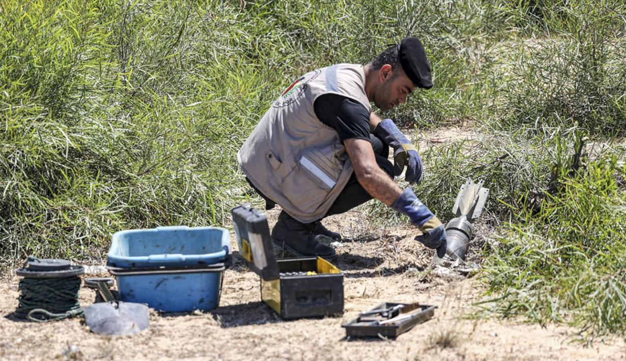 Seorang ahli bahan peledak Hamas menggali proyektil yang tidak meledak setelah konflik Mei 2021 dengan Israel di sebuah lapangan di Khan Yunis, Jalur Gaza, Sabtu (5/6/2021). Perang 11 hari antara Hamas dan Israel menewaskan 254 orang Palestina dan 12 orang Israel. (MAHMUD HAMS/AFP)