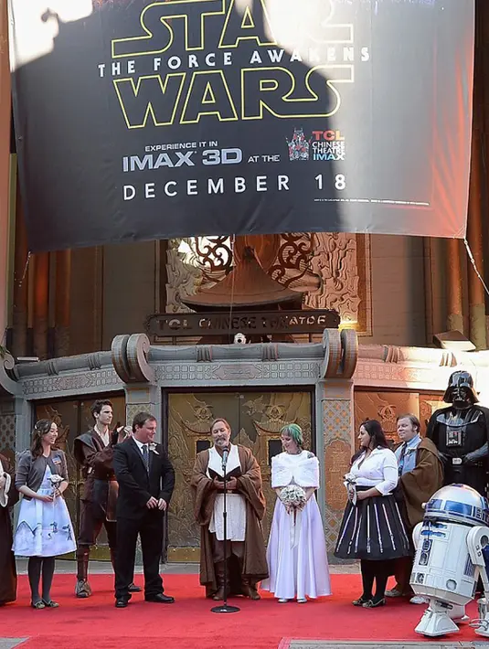 Pasangan Caroline Ritter dan Andrew Porters saat upacara pernikahan bertema Star Wars: The Force Awakens di depan gedung bioskop di Hollywood, Los Angeles,  Kamis (17/12). Pemimpin upacara pernikahan pun mengenakan jubah sang Jedi. (dailymail.co.uk)