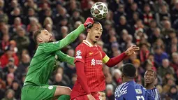 Kiper Paris Saint-Germain, Gianluigi Donnarumma (kiri) berebut bola dengan pemain Liverpool, Virgil van Dijk dalam laga leg kedua Liga Inggris 2024/2025 di Anfield, Inggris, Rabu (12/03/2025) WIB.