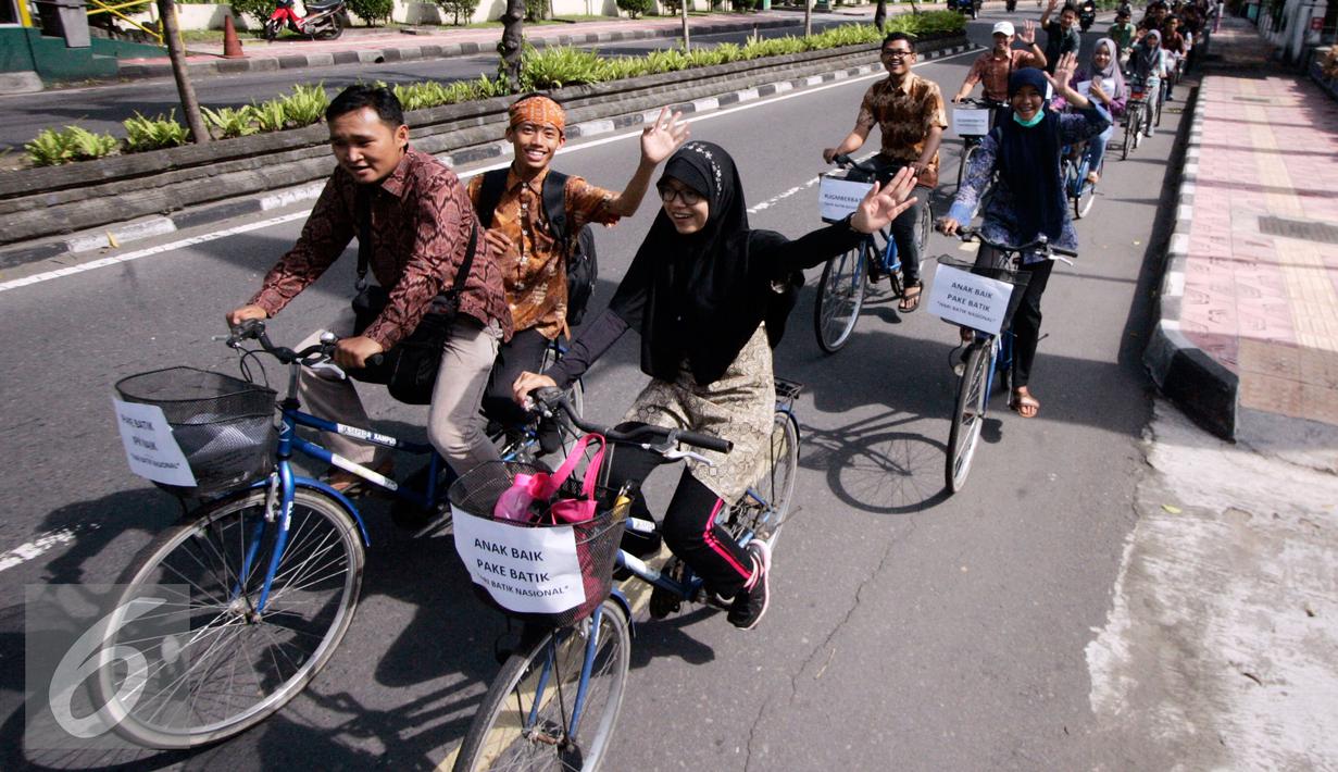 Sejumlah mahasiswa UGM berbusana batik saat pawai sepeda di kawasan Kridosono Yogyakarta, Minggu (2/10). Kegiatan tersebut untuk memperingati Hari Batik Nasional. (Liputan6.com/Boy Harjanto)