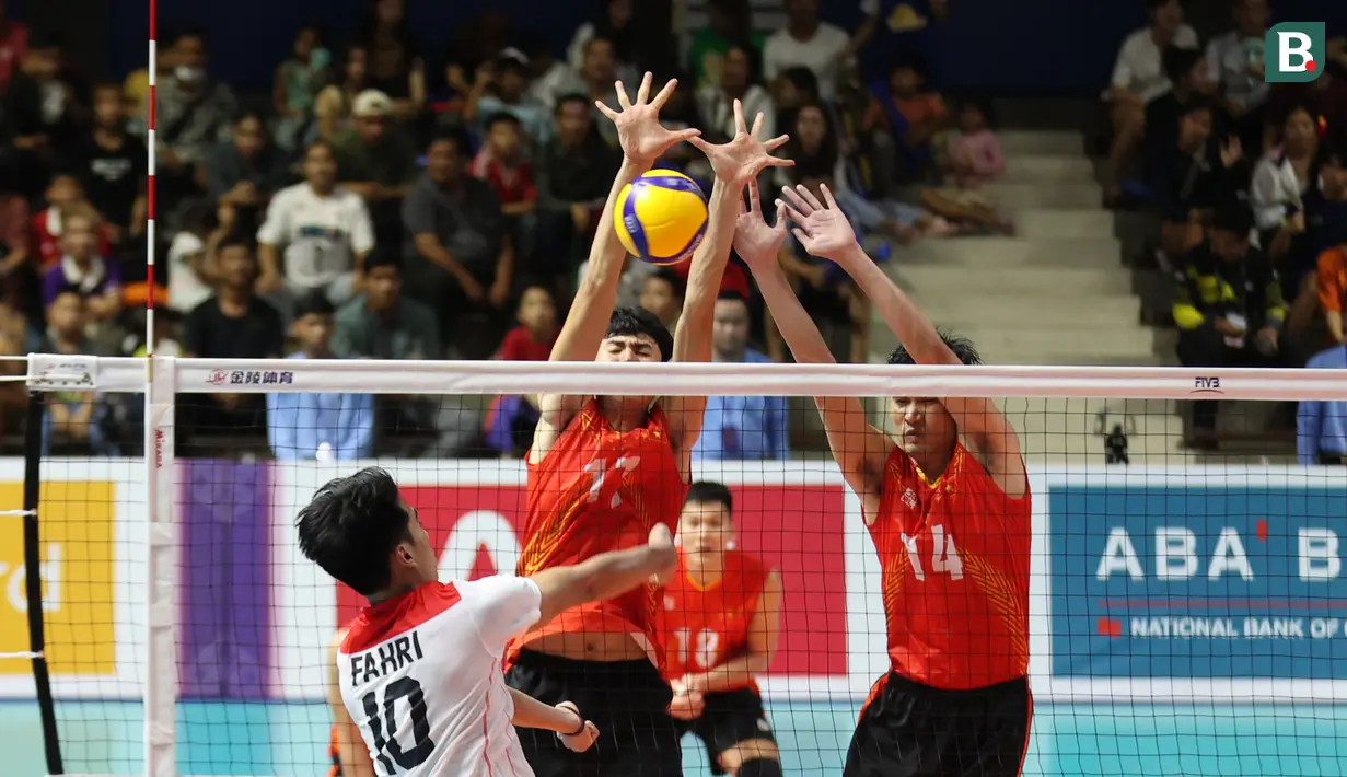 Pemain Timnas voli putra Indonesia, Putratama Fahri Septian (kiri), melakukan smash yang berhasil dihadang oleh pemain Vietnam pada laga Semifinal Bola Voli Putra SEA Games 2023 di Olympic Complex Indoor Main Hall, Phonm Penh, Minggu (7/5/2023). (Bola.com/Abdul Aziz)