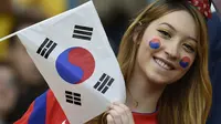 Seorang wanita cantik pendukung Korea Selatan mengibarkan bendera Korsel saat tim kesayangannya berlaga melawan Aljazair di Porto Alegre pada 22 Juni 2014 (AFP PHOTO/PHILIPPE DESMAZES)