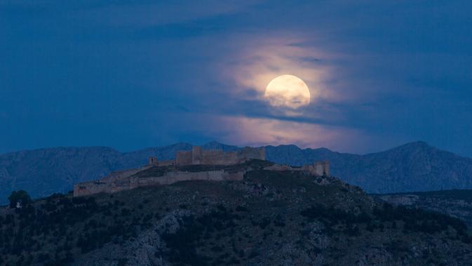 Bulan purnama terlihat di atas Kastil Larisa, Argos, Yunani, Kamis (7/5/2020). Fenomena supermoon atau di belahan Bumi lain disebut flower moon ini merupakan yang terakhir di tahun 2020. (Xinhua/Marios Lolos)