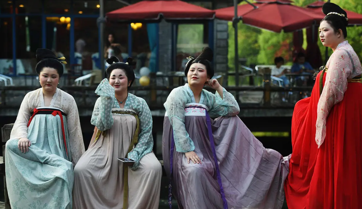 Empat wanita berpose mengenakan kostum Dinasti Tang saat mengunjungi Danau Barat di Hangzhou di provinsi Zhejiang timur China (31/3). Bahan pakaian Dinasti Tang terbuat dari sutra dan terkenal karena kelembutan dan ringan.  (AFP Photo/China Out)